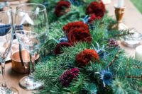 17 an evergreen table runner with bold burgundy blooms and thistles for a rustic winter wedding