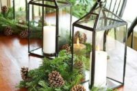 18 an evergreen table runner with pinecone and candle lanterns to remind everyone of winter and holidays coming