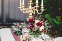19 a tablescape styled with lush blooms and evergreens, gold and marsala for a luxe wedding