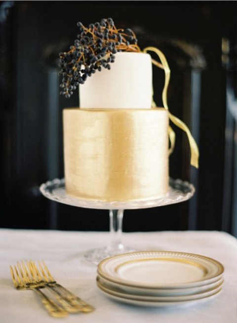 an elegant white and gold wedidng cake topped with a berry branch for a chic winter wedding