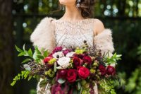 20 a lush and colorful winter wedding bouquet with blackberries, greenery and red and fuchsia roses