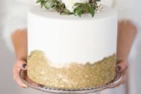 21 a modern wedding cake with gold glitter and fresh greenery and blooms for an elegant wedding