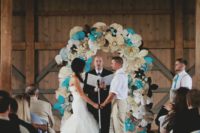 22 a paper flower wedding arch done in turquoise, ivory and black to fit the wedidng color scheme