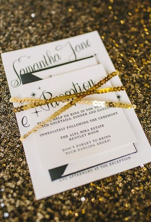 a modern black and white invitation set wrapped with gold sequins