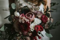 26 a textural winter wedding bouquet with foliage, red blooms, cascading amaranthus and dahlias
