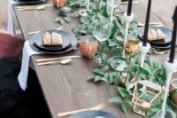 27 a modern foliage table runner with black candles and gilded candle holders for a modern farmhouse wedding