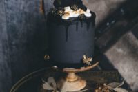 27 an elegant matte black wedding cake with black drip, cream, chocolate shards and gilded blackberries