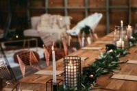 28 a modern greenery table runner with candle lanterns incorporated for an industrial winter wedding