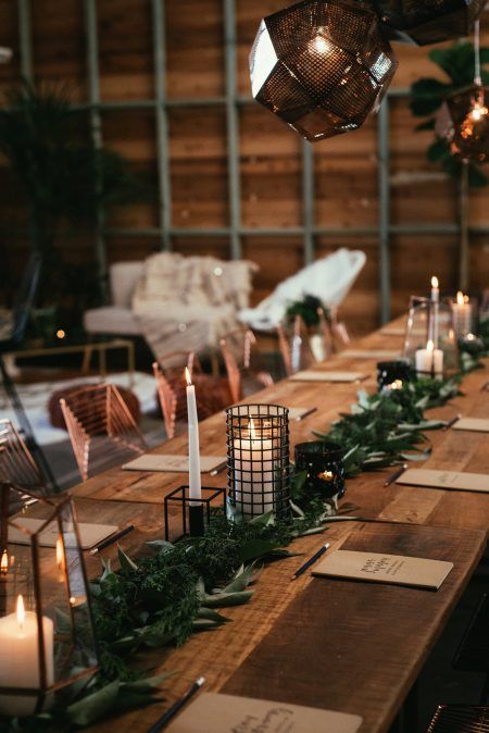 a modern greenery table runner with candle lanterns incorporated for an industrial winter wedding