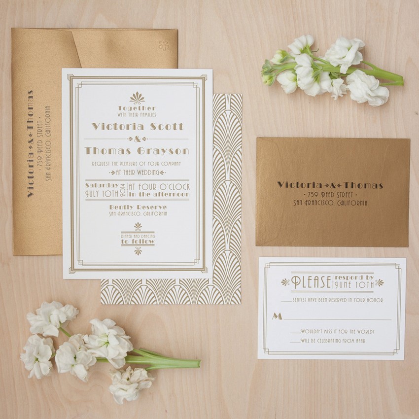 Gold foil and white wedding invites with art deco prints and in gold envelopes