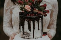 30 a luxurious winter wedding cake with chocolate drip, blackberries, lush blooms and greenery