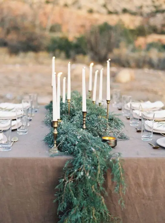 a textural greenery table runner looks very elegant and chic with gilded touches on the table