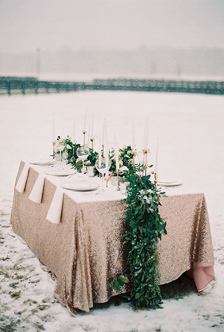 fresh greenery and white blooms table runner looks super bold on a copper tablecloth