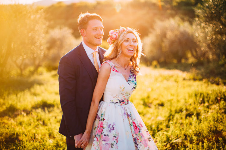 The bride rocked one of the hottest wedidng trends - a floral wedding gown, and added a floral crown, and the groom was wearing a three-piece suit with a yellow tie