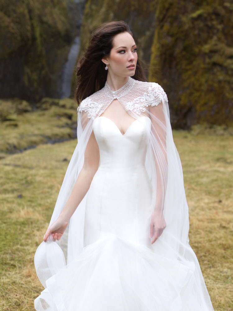 An elegant strapless wedding dress with a ruffled tail and a gorgeous lace beaded cape to highlight it