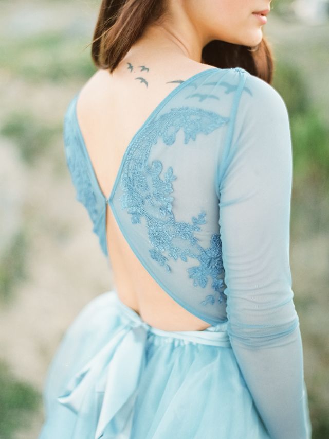 an ice blue wedding dress with an illusion lace top with back cutouts and a flowy skirt