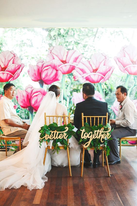 Gold calligraphy chair signs and fresh foliage posies for accentuating tropical wedding chairs