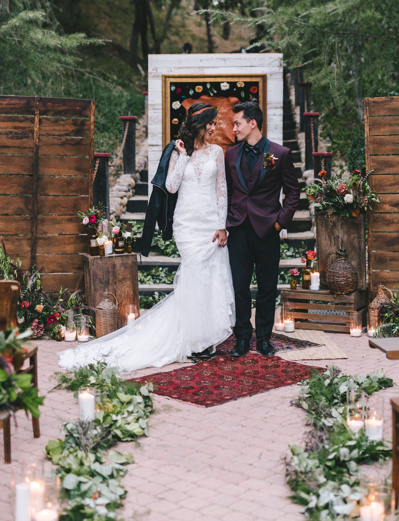The groom was rocking a burgundy suit with black, the bride was wearing a lace wedding dress with an illusion neckline and long sleeves