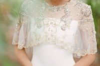 04 a heavily beaded and embroidered capelet over an off the shoulder white wedding dress