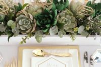04 a lush succulent wedding centerpiece with eucalyptus and geometric toppers for a chic modern look