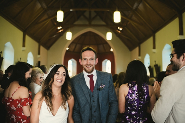 The groom was wearing a grey three-piece wedding suit with a burgundy tie