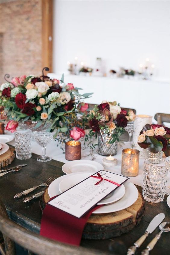 a chic winter tablescape with wood slices as chargers and candle holders