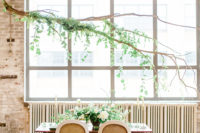 06 The wedding tablescape was accented with branches over it and fresh greenery
