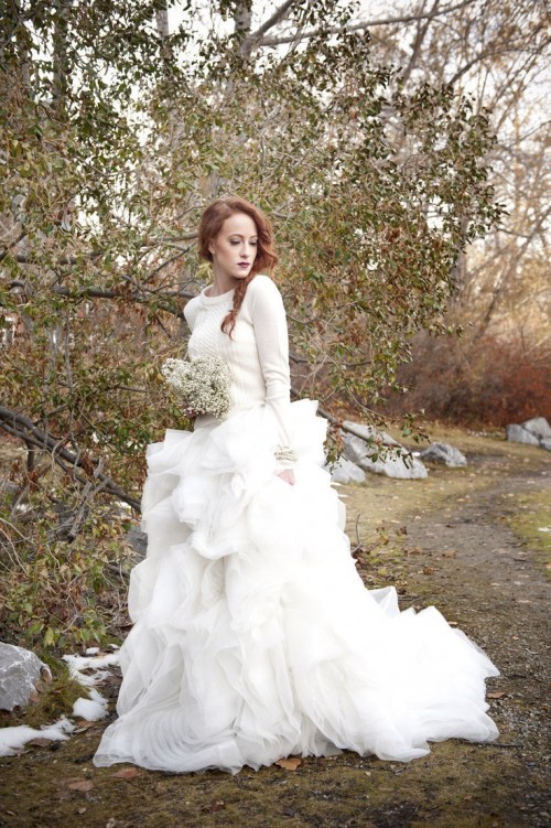 A neutral sweater over the wedding dress looks feminine and winter like