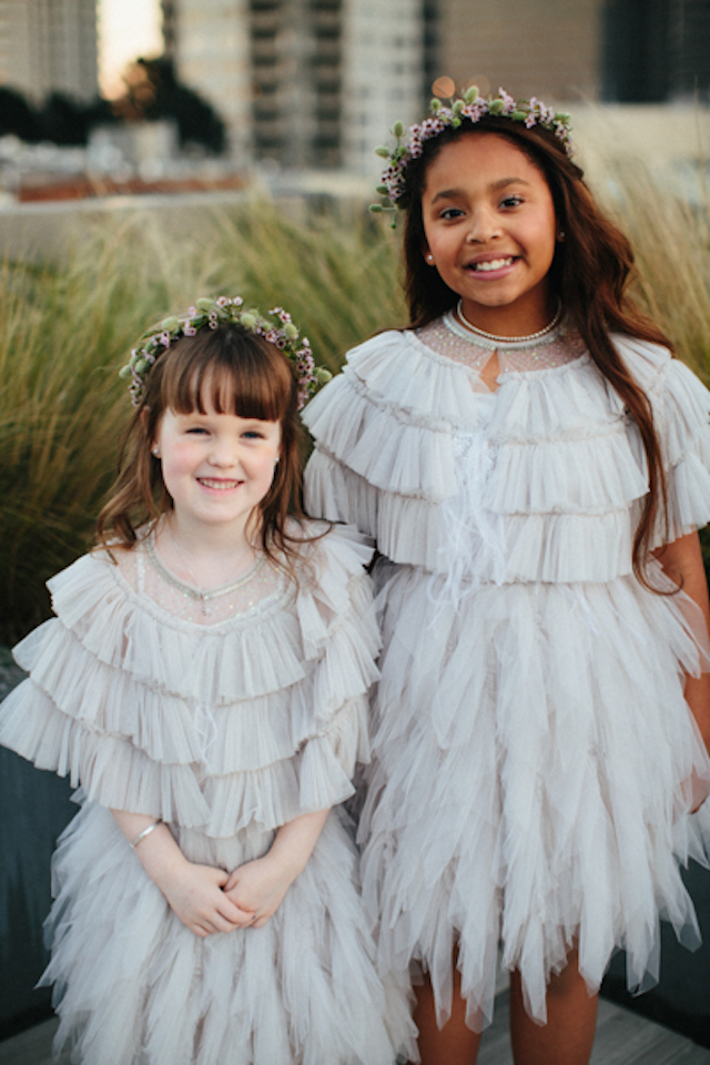 The flower girls were wearing ruffled dresses and floral crowns