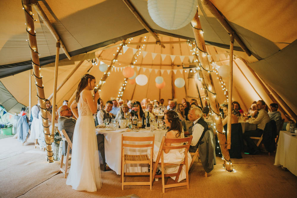 The reception took place in a rustic festival-inspired teepee with lots of lights and banners