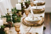 07 a gorgeous winter table setting with wood slice chargers, an evergreen garland and pinecones