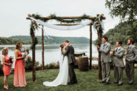 08 The wedding arch was done of wood, greenery, flowy fabric and blooms, the space looked peaceful and quiet