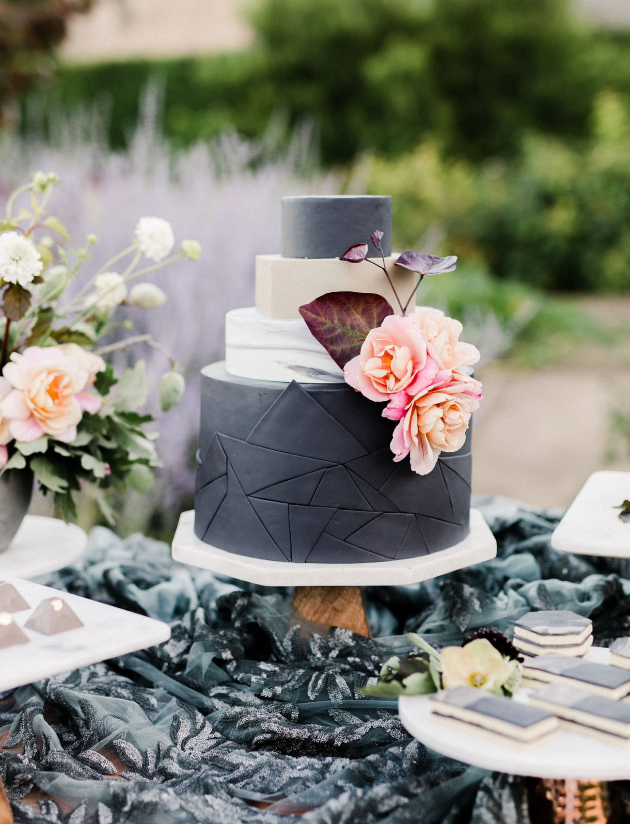 A gorgeous geometric wedding cake in matte black and white with pastel blooms