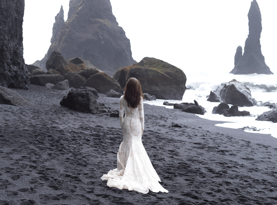 A lace mermaid wedding dress with long sleeves, a small train and a row of buttons on the back