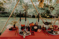 09 The wedidng table was laid with an orange tablecloth, black candles, bold blooms and herbs