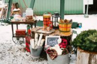 10 a cozy hot chocolate station with pinecones,branches, plaid blankets and fir branches