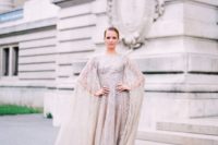 10 a silver glitter wedding dress with a cape attached is a bold sparkly statement