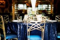 11 a navy sequin tablecloth, gold details and a tall white bloom centerpiece for a glam wedding