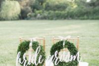 11 white calligraphy signs with lush boxwood wreaths and neutral ribbons are ideal for a Christmas wedding