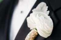 13 a buttonhole with white ranunculus and gold sequin wrap for a touch of sparkle