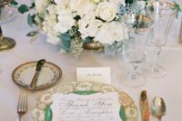 13 a glam table setting in emerald and gold, with a lush floral centerpiece and emerald linens