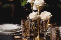 13 a refined tablescape with sparkly chargers, gold rim glasses and gold rose stands with white blooms