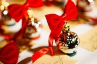 13 display your escort cards with little cute ornaments with red bows to give them a Christmas feel