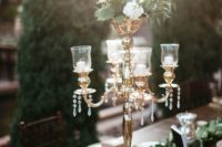 14 a gorgeous glam tablescape with vintage candle holders, liush foliage and white blooms