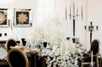15 a gorgeous black and gold wedding tablescape with a lush white bloom runner and black chairs for a match