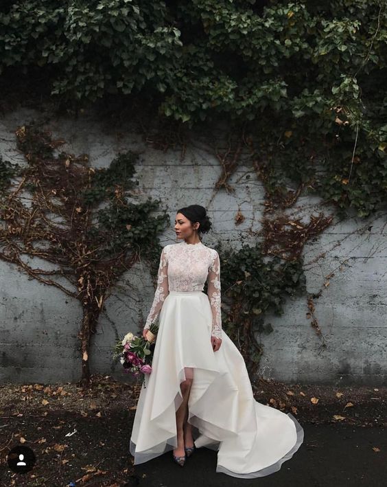 a gorgeous high low wedding dress with a turtleneck, illusion bodice and sleeves and a chic skirt