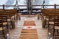 15 a mountain wedding ceremony space with a boho rug, candles and snowy branches and a gorgeous view behind