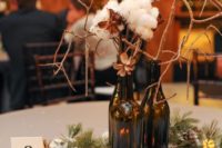 16 a cozy winter centerpiece with snowy pinecones, evergreens, candles, cottons and wine bottles with branches