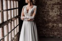 16 a wedding gown with a lace bodice with an illusion plunging neckline, long sleeves and a slowy skirt with a train