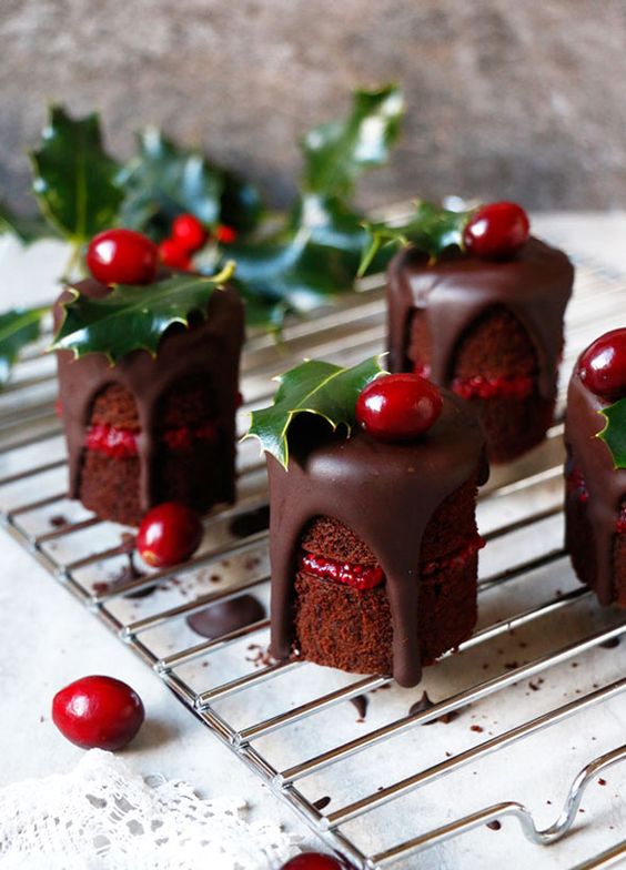 mini naked chocolate cakes with berry compote and chocolate dripping, cranberries and leaves on top scream Christmas